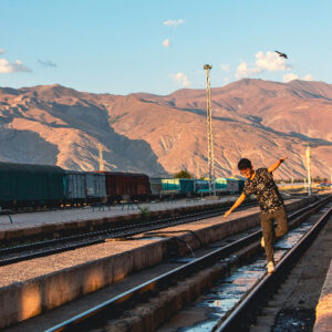 teenage-boy-balancing-on-railway-tracks-