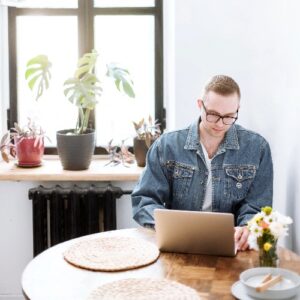 man in blue denim-jacket sitting by the table